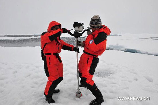 Chinese expedition team members drill for ice samples on the ice in the Arctic Ocean, Aug. 2, 2010. The team members carried out science expeditions on a floating ice Monday in the Arctic Ocean. [Photo: Xinhua]