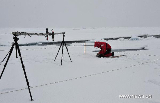 A Chinese expedition team member tests the sun reflection on the ice in the Arctic Ocean, Aug. 2, 2010. [Photo: Xinhua]