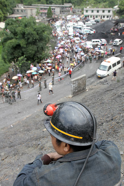 A miner waits for latest news about his trapped colleagues after a gas outburst at the Mingyang Coal Mine in Changgang township, Renhuai city, Southwest China&apos;s Guizhou province, August 3, 2010. [Xinhua] 