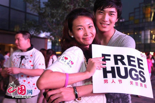 People ccelebrate International Men&apos;s Day (IMD) at Sanlitun Village in Beijing, August 3, 2010. Several men hold a slogan of &apos;Free Hugs&apos; to ask strangers for a hug during a &apos;Free Hug&apos; event. [CFP]