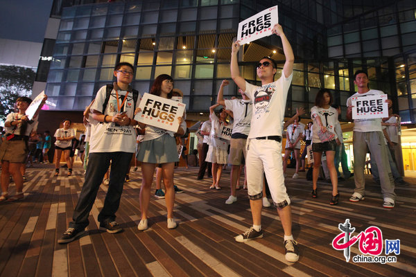 People ccelebrate International Men&apos;s Day (IMD) at Sanlitun Village in Beijing, August 3, 2010. Several men hold a slogan of &apos;Free Hugs&apos; to ask strangers for a hug during a &apos;Free Hug&apos; event. [CFP]