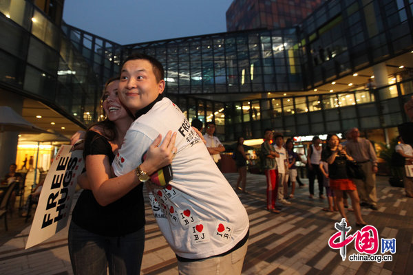 People ccelebrate International Men&apos;s Day (IMD) at Sanlitun Village in Beijing, August 3, 2010. Several men hold a slogan of &apos;Free Hugs&apos; to ask strangers for a hug during a &apos;Free Hug&apos; event. [CFP]