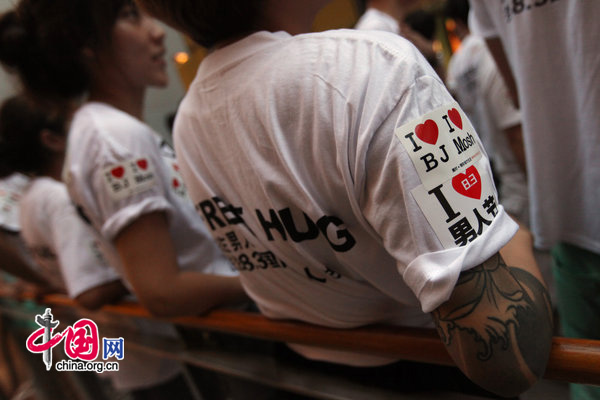 People ccelebrate International Men&apos;s Day (IMD) at Sanlitun Village in Beijing, August 3, 2010. Several men hold a slogan of &apos;Free Hugs&apos; to ask strangers for a hug during a &apos;Free Hug&apos; event. [CFP]