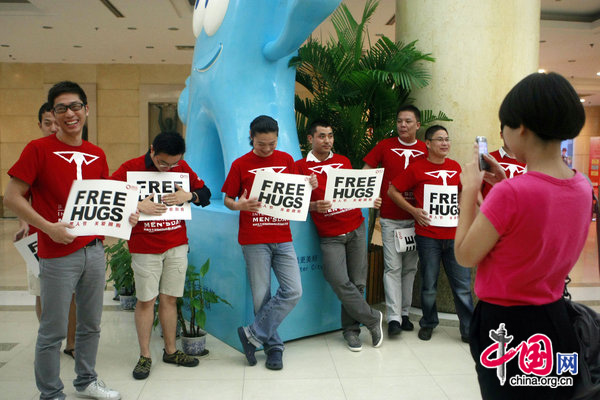 People ccelebrate International Men&apos;s Day (IMD) at Sanlitun Village in Beijing, August 3, 2010. Several men hold a slogan of &apos;Free Hugs&apos; to ask strangers for a hug during a &apos;Free Hug&apos; event. [CFP]