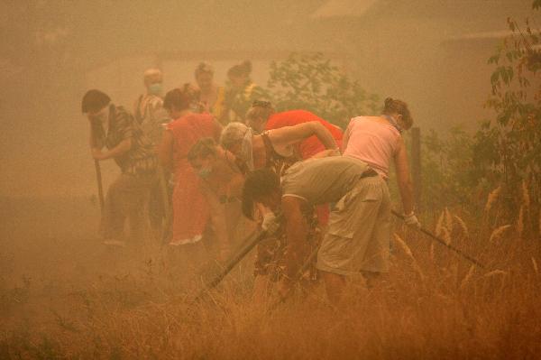 Locals dig a trench to prevent against spread of wildfire in the burnt out village of Mokhovoye, Lukhovitsi municipal district, some 130 kilometers from Moscow, August 3, 2010. [Xinhua/AFP]