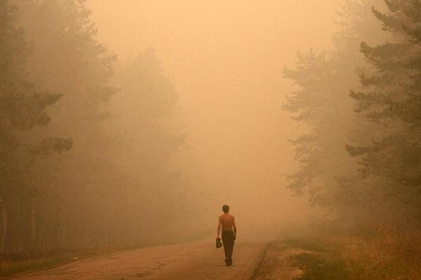  A Russian man walks along the the street in the burnt out village of Mokhovoye, Lukhovitsi municipal district, some 130 kilometers from Moscow, August 3, 2010.[Xinhua/AFP]