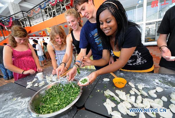 American high school students make dumplings in Nanjing, capital of Jiangsu Province, Aug. 3, 2010. Eighty American high school students attend the 'Chinese Bridge' camp in Nanjing First High School. They will spend 10 days to learn Chinese culture and traditional Chinese arts like calligraphy, painting, paper cutting, etc. [Sun Can/Xinhua]