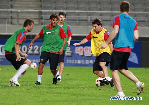 Barcelona's Lionel Messi of Argentina fights for the ball with his teammates during a training session in Seoul August 3, 2010. South Korea's K-league all-star soccer team and Spain's Barcelona will have match in Seoul on Aug. 4. (Xinhua/Park Jin-hee) 