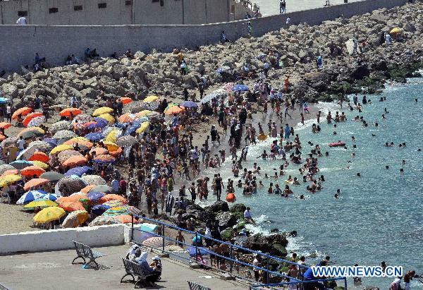 People enjoy themselves during the summer vacation at the rocky coast and beach near Algiers, Algeria, Aug. 3, 2010. (Xinhua/Kadri Mohamed)