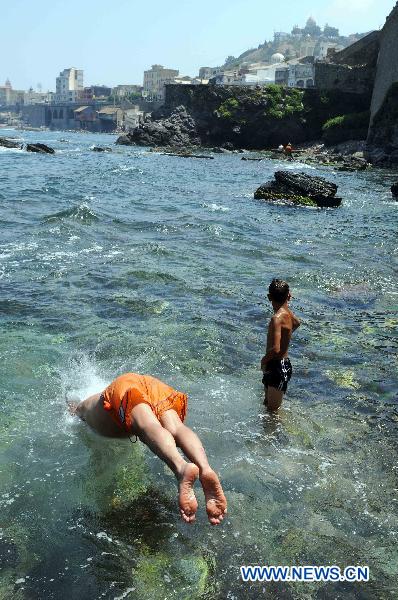 People enjoy themselves during the summer vacation at the rocky coast and beach near Algiers, Algeria, Aug. 3, 2010. (Xinhua/Kadri Mohamed)