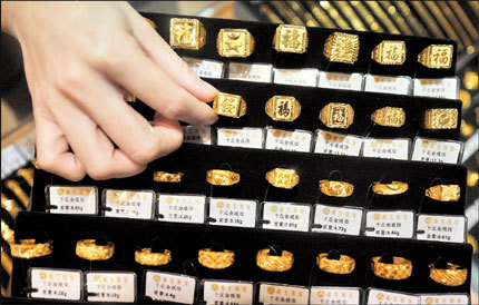 A sales assistant arranges gold rings at a jewelry store in Haikou, Hainan Province, yesterday. China yesterday said it will further open its gold market and improve tax policies for investment in the precious metal. [Shanghai Daily]