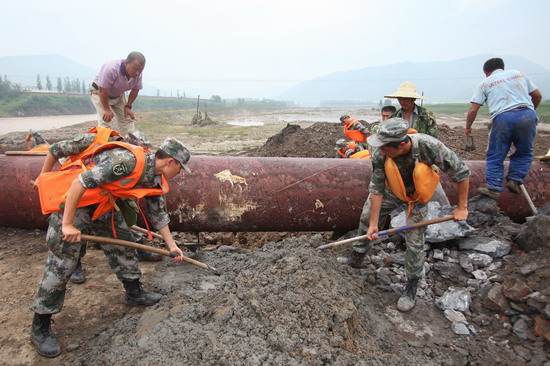 Soldiers repair a flood-damaged water pipe on Tuesday on the outskirts of Tonghua, Jilin province. 