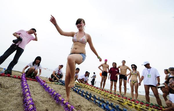 A member of the Russian summer camp to China dances at beach in Dalian, northeast China&apos;s Liaoning Province, Aug. 4, 2010. Some 300 Russian students arrived in Dalian Wednesday for a four-day tour as part of the ten-day summer camp to China invited by Chinese President Hu Jintao. [Xinhua] 