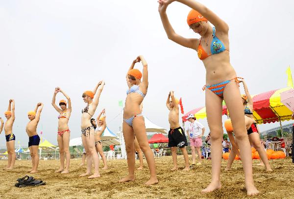 Members of the Russian summer camp to China do exercise at beach in Dalian, northeast China&apos;s Liaoning Province, Aug. 4, 2010. Some 300 Russian students arrived in Dalian Wednesday for a four-day tour as part of the ten-day summer camp to China invited by Chinese President Hu Jintao. [Xinhua] 