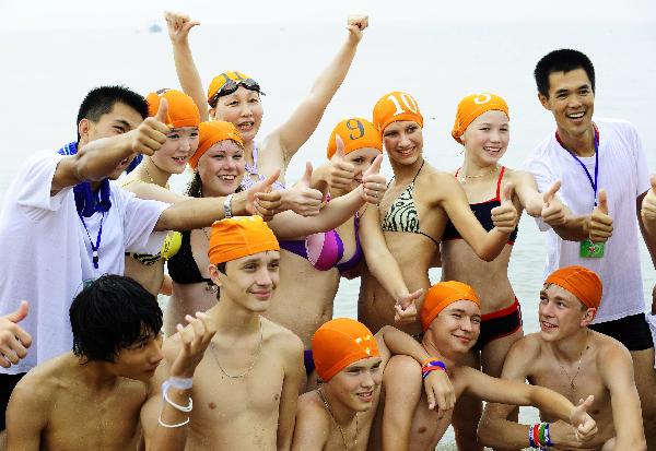 Members of the Russian summer camp to China and Chinese staff pose for a photo at beach in Dalian, northeast China&apos;s Liaoning Province, Aug. 4, 2010. Some 300 Russian students arrived in Dalian Wednesday for a four-day tour as part of the ten-day summer camp to China invited by Chinese President Hu Jintao. [Xinhua] 
