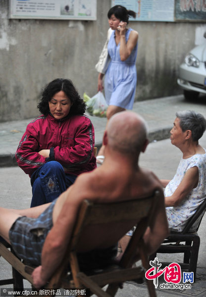 Luo Chun&apos;e (in red) chats with neighbors near her house in Wuhan, Central China&apos;s Hubei province, August 4, 2010. [CFP]