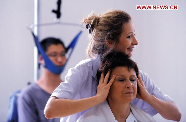 A French student practices massage in Shengyang, capital of Liaoning Province, Aug. 4, 2010. A total of ten French students came to Shenyang on Wednesday, and they will spend two weeks to learn traditional Chinese Medicine such as acupuncture and massage from Chinese doctors. [Yang Xinyue/Xinhua]