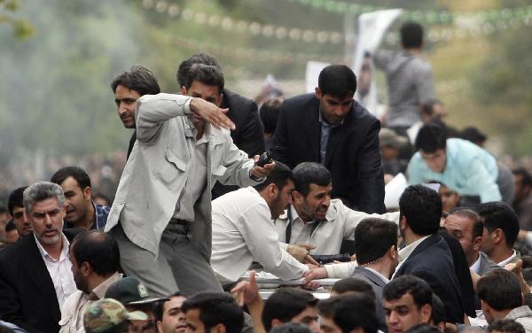 Bodyguards react after the sound of an explosion behind the entourage of Iranian President Mahmoud Ahmadinejad (C) as he is welcomed to Hamadan, 336 kilometres southwest of Tehran, August 4, 2010.[Xinhua]