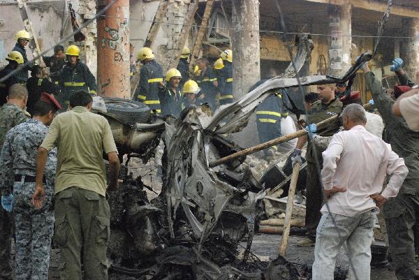 Security personnel gather at the site of a bomb attack in Kut, 150 km (95 miles) southeast of Baghdad, August 3, 2010. Two bombs exploded in the usually quiet southern city of Kut in Iraq&apos;s Wasit province on Tuesday. [Xinhua]