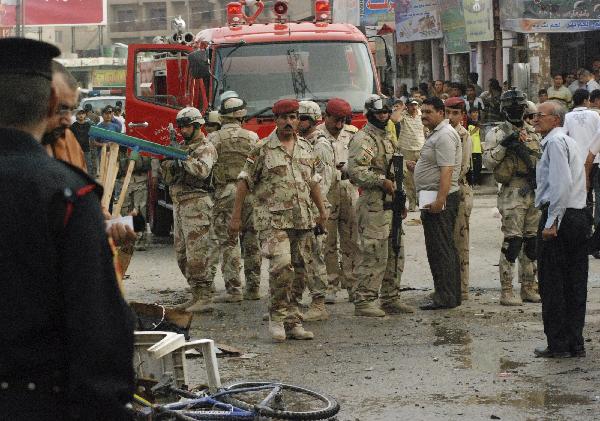 Iraqi soldiers inspect the site of a bomb attack in Kut, 150 km (95 miles) southeast of Baghdad, August 3, 2010. Two bombs exploded in the usually quiet southern city of Kut in Iraq&apos;s Wasit province on Tuesday. Picture taken August 3, 2010. [Xinhua]