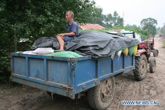 Villagers evacuate before the rainstorms come in Nong'an County near Changchun, capital of northeast China's Jilin Province, Aug. 4, 2010. According to local meteorological department, rainstorms will hit Jilin City and Changchun of the province from Aug. 4 to 6. Some 12.8 thousand people were evacuated to safe places by far. [Xinhua] 