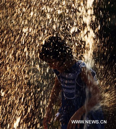 A girl enjoys herself at a fountain in a zoo in Taipei, southeast China&apos;s Taiwan, Aug. 4, 2010. The temperature reached 36 degrees Celsius in Taipei on Wednesday. (Xinhua/Fei Maohua) (ly) 