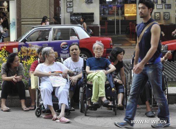 Residents rest at Time Square in Hong Kong, south China, Aug. 4, 2010. Hong Kong Observatory announced on Wednesday an extreme hot weather alert reminding residents not to be exposed in sun for long. [Xinhua]