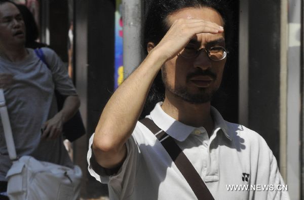 A man shades himself in sun in Hong Kong, south China, Aug. 4, 2010. Hong Kong Observatory announced on Wednesday an extreme hot weather alert reminding residents not to be exposed in sun for long. [Xinhua]