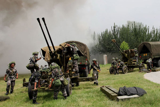 An artillery unit in position is poised for firing during the five-day military exercise code-named 'Vanguard-2010,' across Henan and Shandong provinces, August 4, 2010. [Photo/Xinhua]
