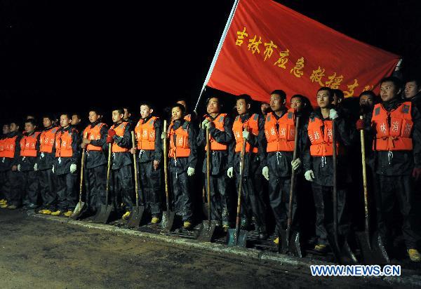 Rescuers gather before heading out to protect the river dike in Yongji County, northeast China&apos;s Jilin Province, Aug. 5, 2010. [Xinhua]