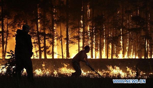 Two man are fighting with rampant wildfires in the central Russia, on Aug 4.[Xinhua]