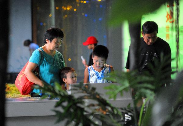 Children and their parents visit at China&apos;s Wetland Museum in Hangzhou, capital of east China&apos;s Zhejiang Province, Aug. 5, 2010.