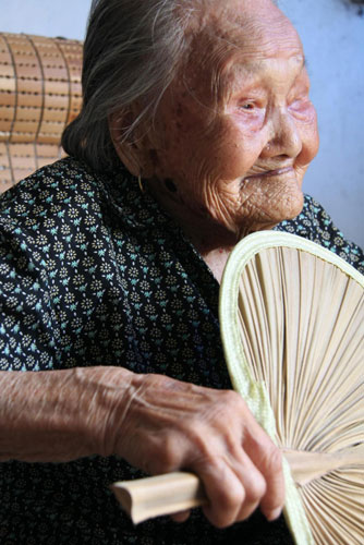 102-year-old Cui Bozhen waves a fan on a summer day in Xichang town of Hai'an county, Jiangsu province, August 4, 2010. 