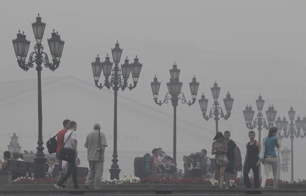 People walk in central Moscow as a heavy smog caused by peat fires in nearby forests shrouded the capital, August 6, 2010. [Xinhua] 