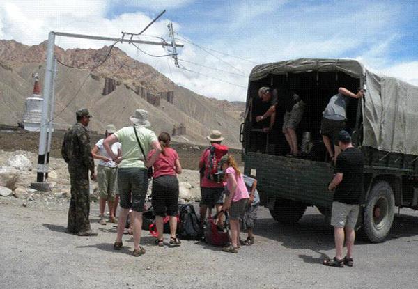 Foreign tourists get on a military vehicle to flee the Indian-controlled Kashmir, on August 6, 2010. At least 85 people were killed and scores injured on Friday after flash floods hit a major town in the mountainous area of Ladakh in Indian-controlled Kashmir, officials said.[Xinhua] 