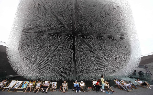 People rest on chaise longues near the Britain Pavilion in 2010 World Expo Site in Shanghai, China, Aug. 6, 2010. Painted chaise longues designed by famous designers from Britain and China were brought to Expo recently. [Xinhua]