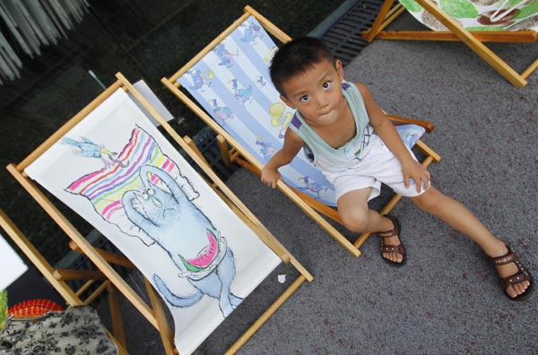 People rest on chaise longues near the Britain Pavilion in 2010 World Expo Site in Shanghai, China, Aug. 6, 2010. Painted chaise longues designed by famous designers from Britain and China were brought to Expo recently. [Xinhua]