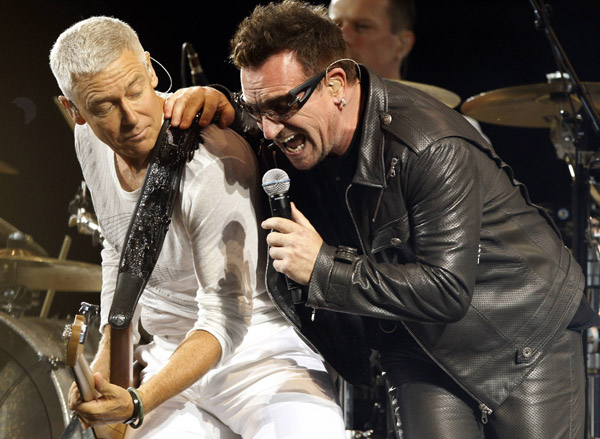 Lead singer Bono (R) and bass player Adam Clayton of Irish rock band U2 perform a concert at the Olympic stadium in Turin, northern Italy August 6, 2010. U2 singer Bono is ready to rock after back surgery sidelined him for two months, and forced the band to postpone its North American tour by a year to May 2011. The Irish rockers began the second European leg of their &apos;360 Degree&apos; world tour on Friday in Italy. 