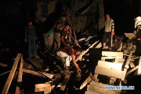 People remove debris of a damaged house in Kargil some 235 kilometers from Leh in Ladakh, India-controlled Kashmir, August 6, 2010. (Xinhua Photo/Javed Dar)