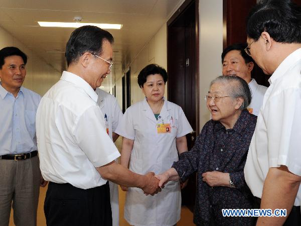 Chinese Premier Wen Jiabao (2nd L) shakes hands with Gu Youfen (3rd, R), wife of optical physicist Wang Daheng, in Beijing, capital of China, Aug. 7, 2010. [Rao Aimin/Xinhua]