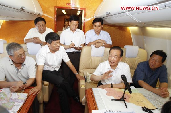Chinese Premier Wen Jiabao speaks during an urgent meeting on disaster relief of the landslide-hit Zhouqu County during the flight en route to the site, Aug. 8, 2010. Wen Jiabao Sunday left Beijing for landslide-hit Zhouqu County, Gannan Tibetan Autonomous Prefecture in northwestern Gansu Province. [Li Xueren/Xinhua]