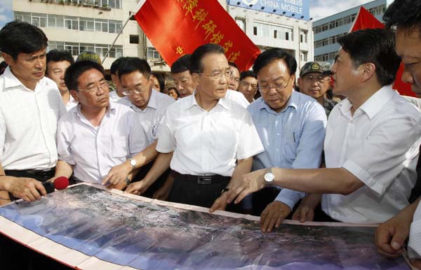 Chinese Premier Wen Jiabao (C, front) instructs the rescue missions in Zhouqu County, Gannan Tibetan Autonomous Prefecture in northwest China&apos;s Gansu Province, Aug. 8, 2010. 127 people have been confirmed dead, 76 others injured and 2,000 missing as of 4 pm on Sunday in landslides triggered by torrential rains in Zhouqu County. [Xinhua] 