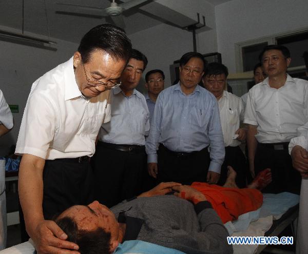 Chinese Premier Wen Jiabao(L front) visits an injured person who got hurt during the landslides at a hospital in Zhouqu County, Gannan Tibetan Autonomous Prefecture in northwest China&apos;s Gansu Province, Aug. 8, 2010. [Xinhua]