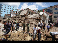 Rescuers search for survivors on the debris after a landslide in Zhouqu County, Gannan Tibetan Autonomous Prefecture in Gansu Province, August 8, 2010. [Xinhua]