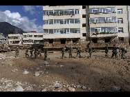 Soldiers remove mud and rocks in front of buildings in search of buried bodies after a landslide in Zhouqu County, Gannan Tibetan Autonomous Prefecture in Gansu Province, August 8, 2010. [Xinhua]