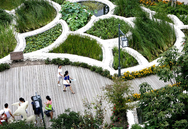 Plant beds and ponds shaped like fish scales form part of a water purification system in the Chengdu Case Pavilion at the Expo, Aug 8, 2010. The artificial wetland, with dozens of different kinds of plants, filtrates and purifies 15 tons of sewage each day. The Chengdu Case Pavilion is a miniature version of Chengdu&apos;s Living Water Park, a system that naturally cleans water from the city&apos;s Funan River using water rehabilitation systems. [Xinhua]