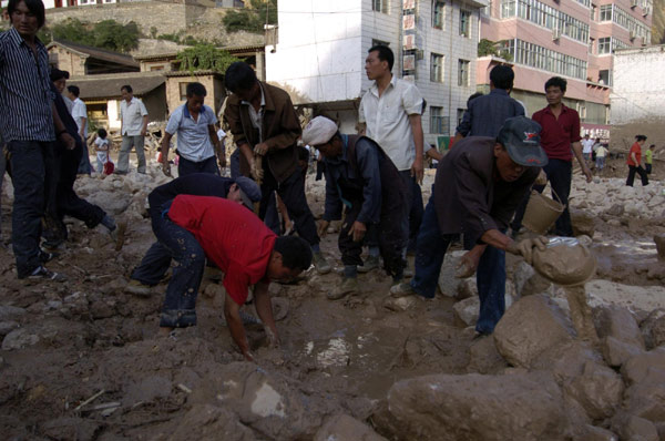Local residents search for survivors in the debris after a landslide hit Zhouqu county, Gannan Tibetan autonomous prefecture in Northwest China&apos;s Gansu province, Aug 8, 2010. [Xinhua]