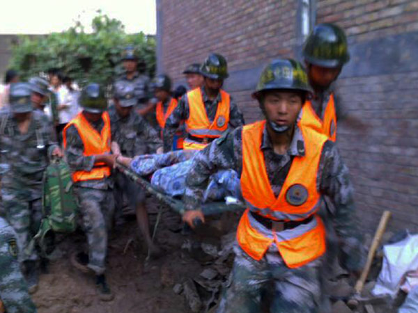 Armed police officers carry a survivor after a landslide in Zhouqu county, Gannan Tibetan autonomous prefecture in Northwest China&apos;s Gansu province, Aug 8, 2010. [Xinhua]