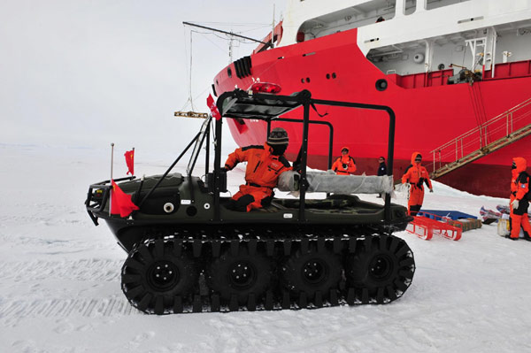 An expedition member drives an all-terrain vehicle to load and transport goods to the fixed ice station built by the Chinese expedition team. [Xinhua]