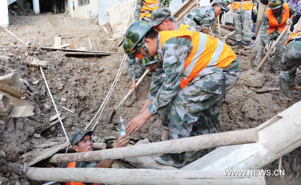 Soldiers provide nutritional supplies for a survivor in landslide-hit Zhouqu County, Gannan Tibetan Autonomous Prefecture in northwest China&apos;s Gansu Province, Aug. 8, 2010. Soldiers sent by the Lanzhou Military Area Command of the Chinese People&apos;s Liberation Army have saved 9 people from rain-triggered landslides in Zhouqu County. [Xinhua]